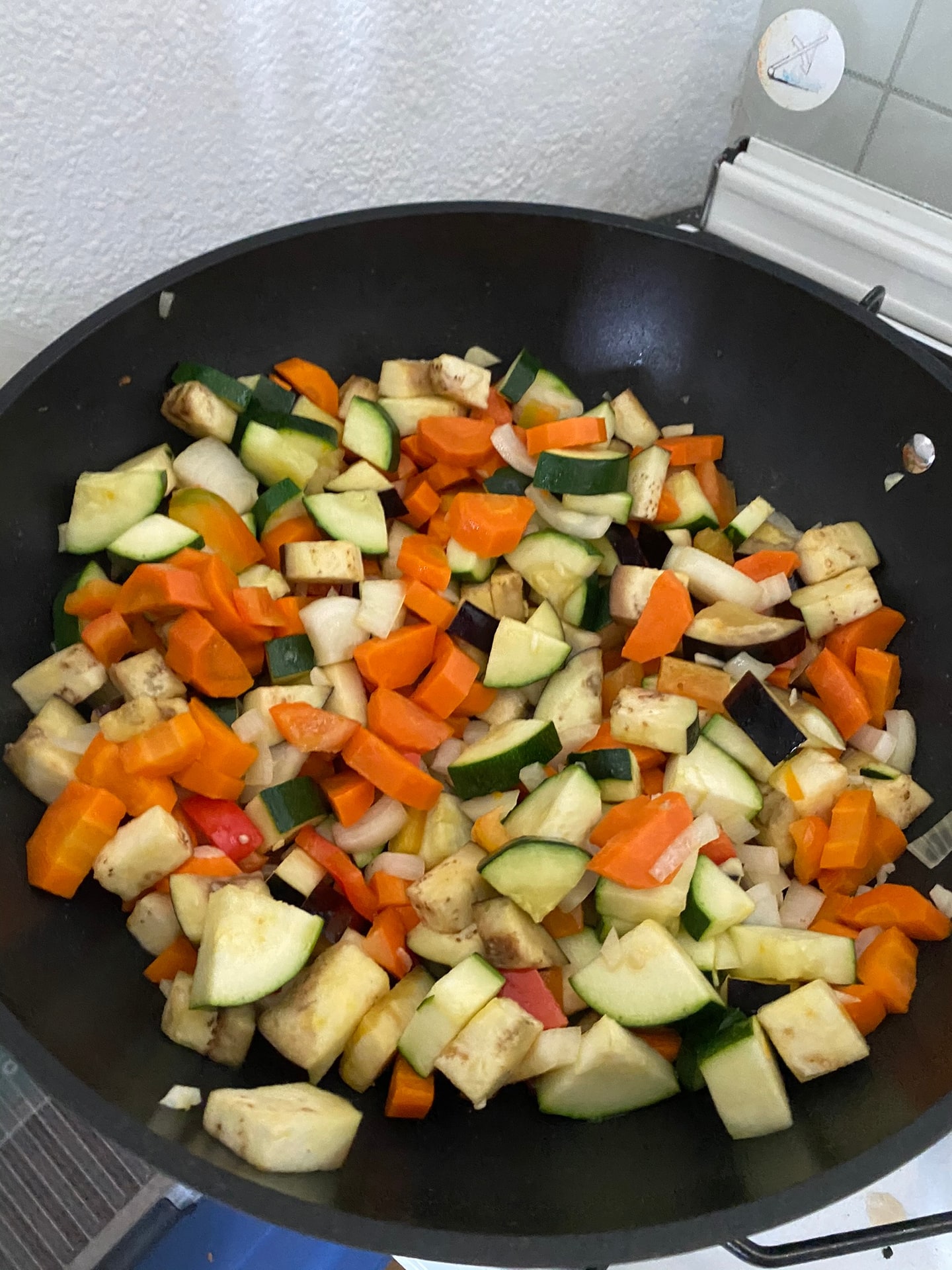 Gesneden courgette, wortel, aubergine en paprika in een wok