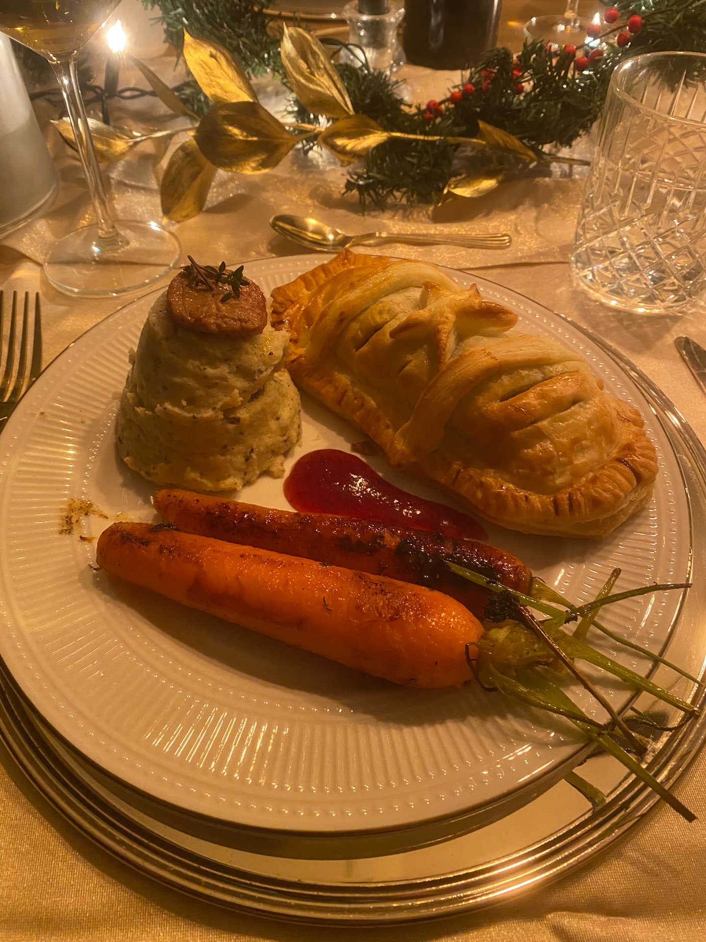 Het hoofdgerecht van het kerstdiner, met het bladerdeeghapje, geroosterde peen en pastinaakpuree
