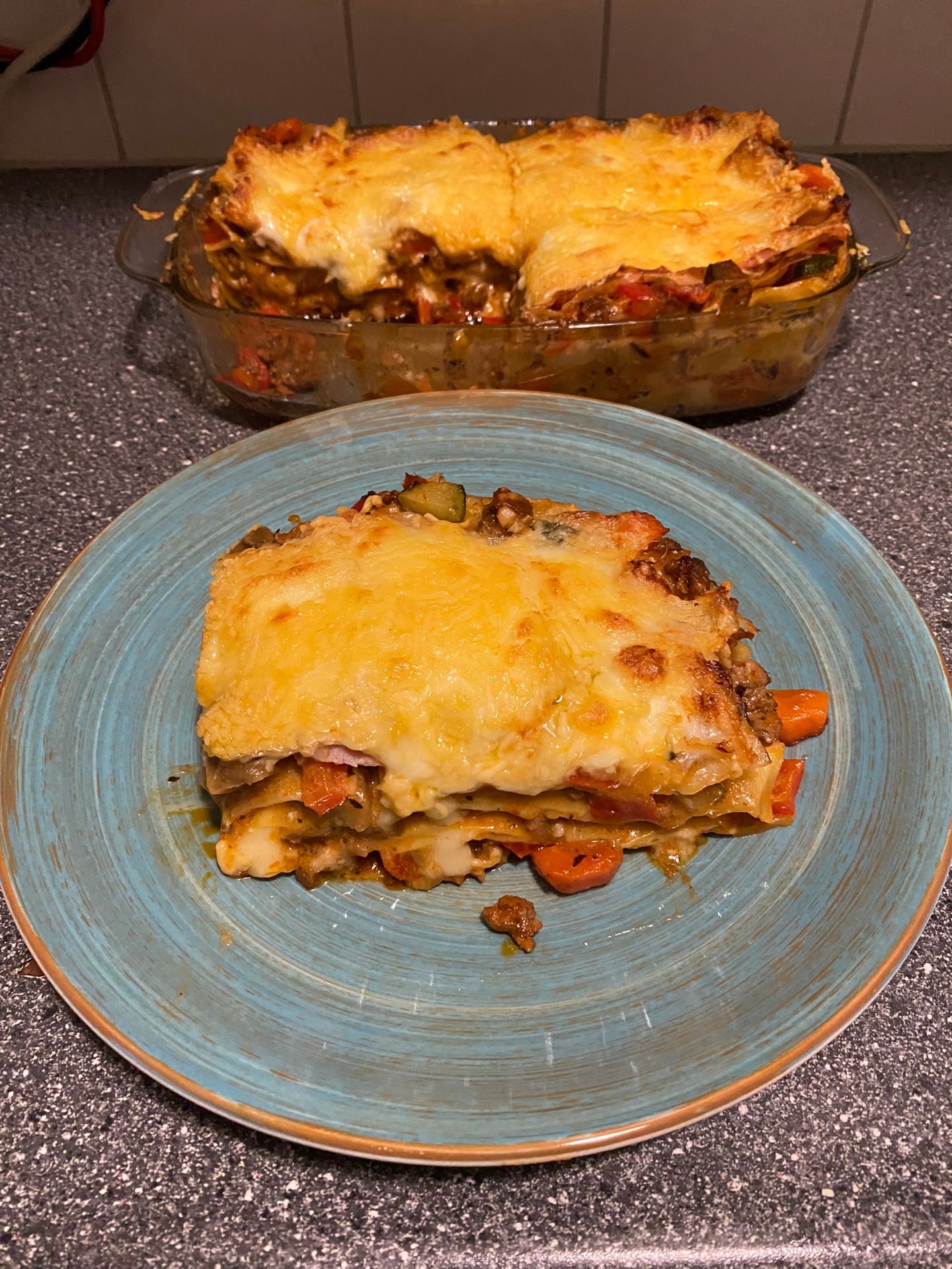 De gebakken lasagne, met een punt op een bord ernaast