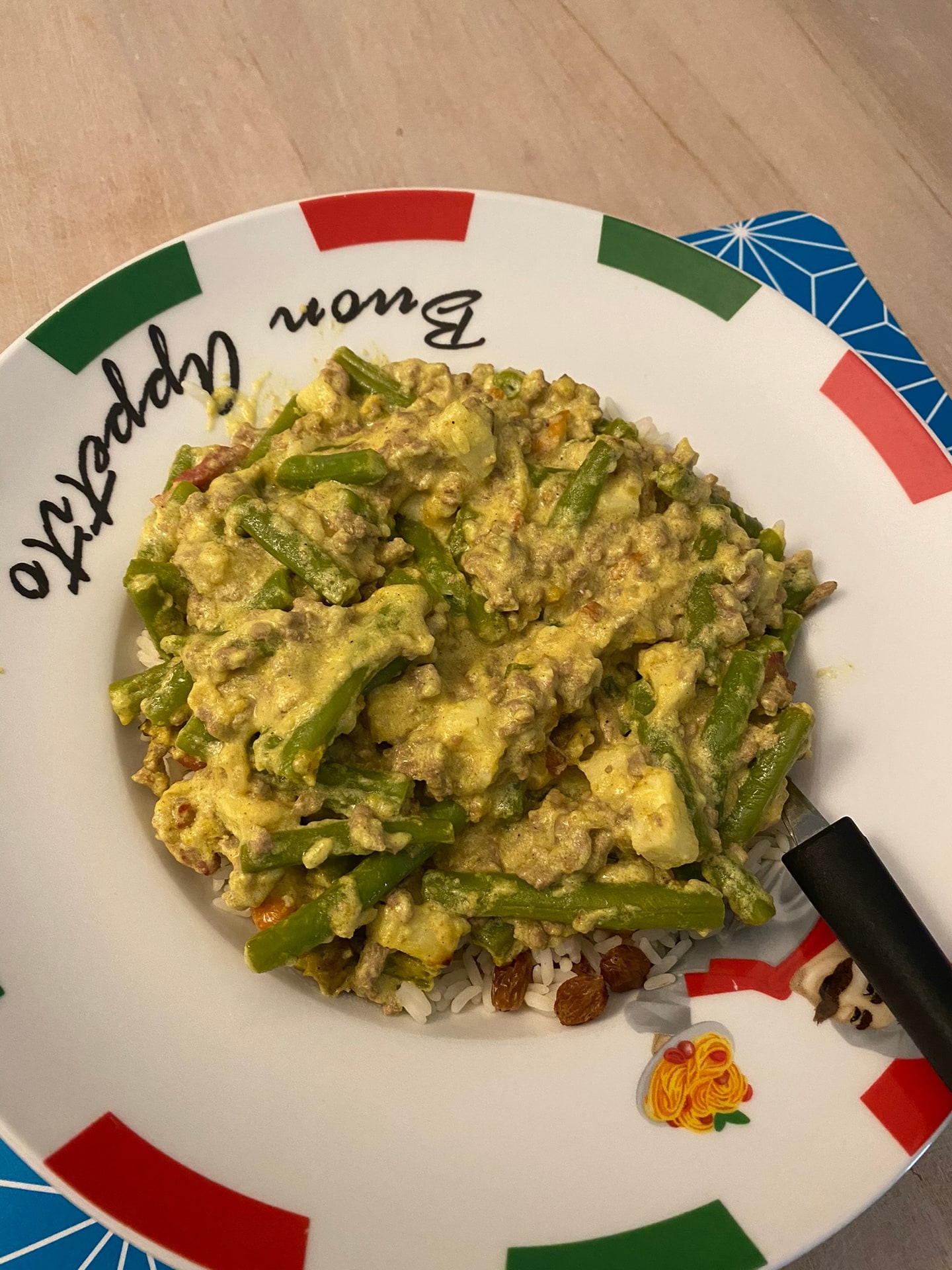 Roerei met sperziebonen en rijst op een bord met Buon Appetito erop