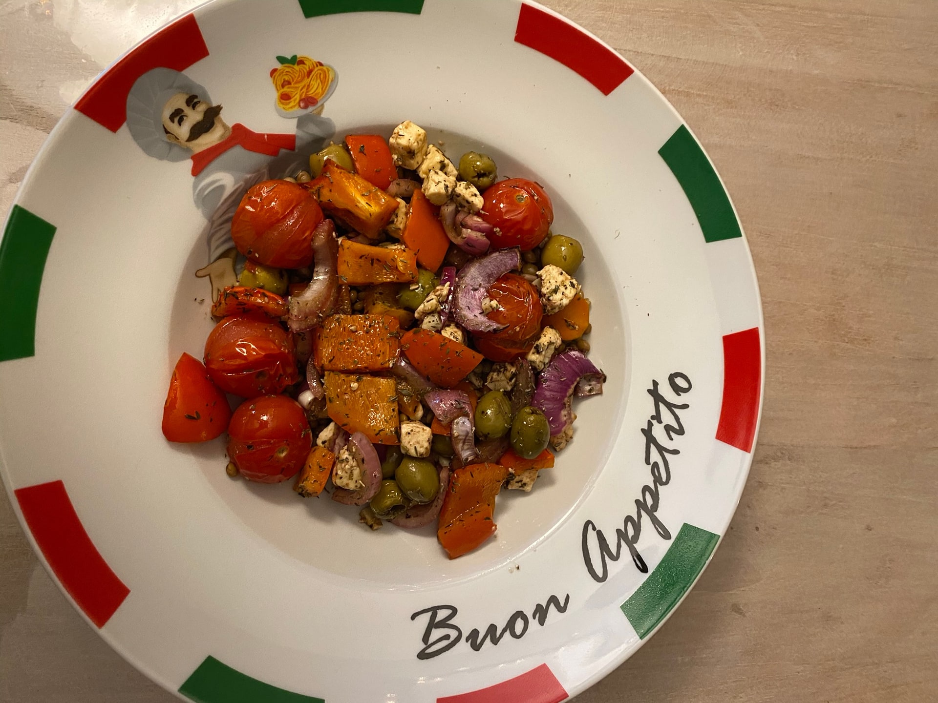 Geroosterde tomaat, pompoen, olijven en feta op een bord
