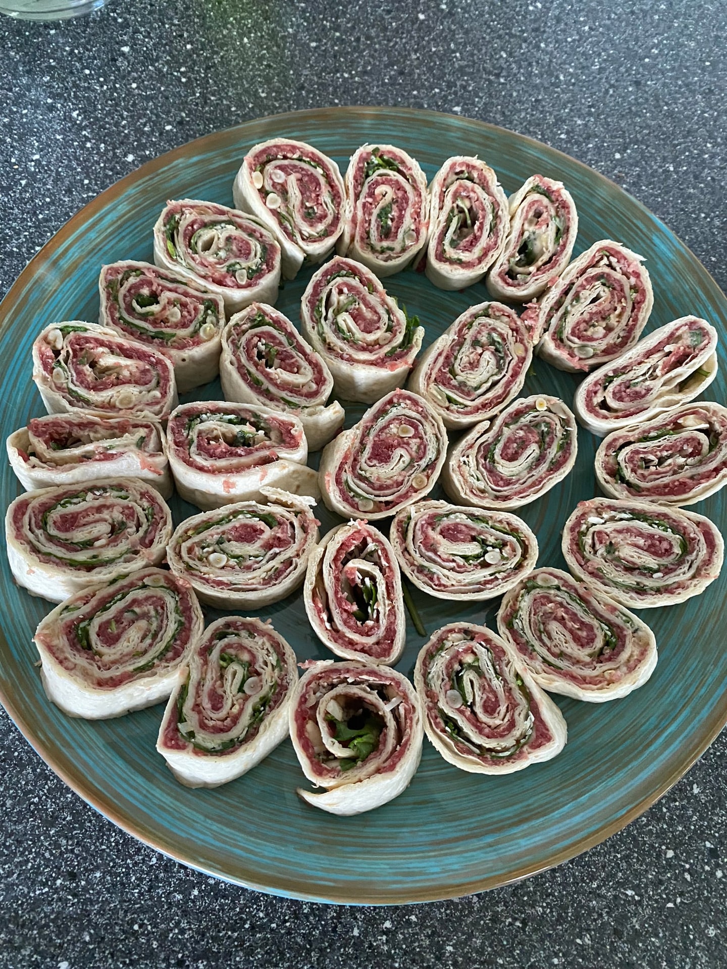 Opgerolde wraps met ham, in een cirkel op een schaal