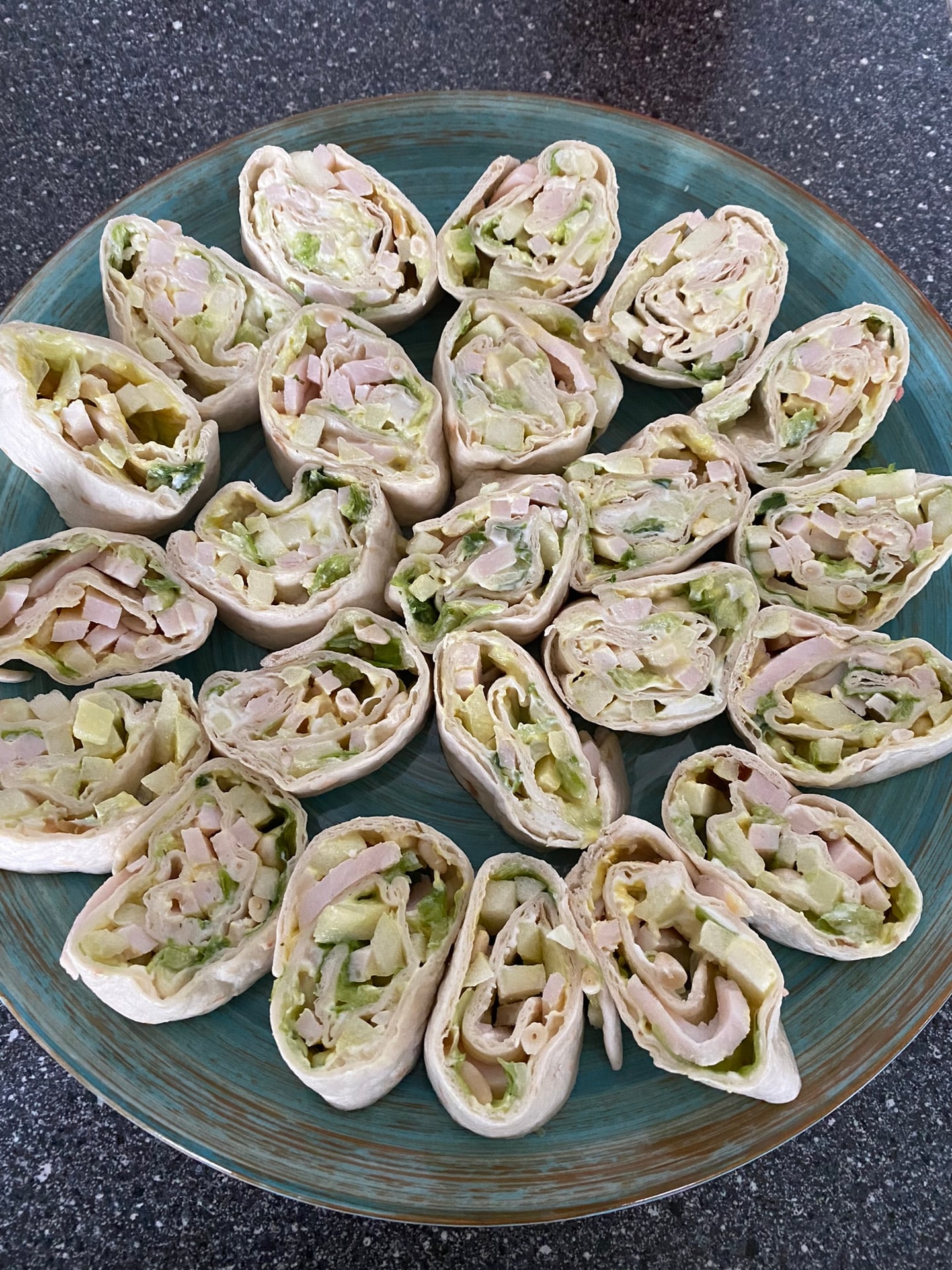 Opgerolde wraps met roomkaas en kruiden, op een schaal