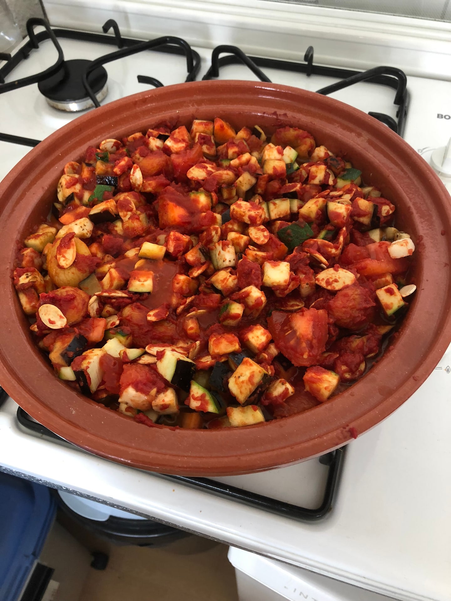 Een pan met tomaat, aubergine en blokjes groente