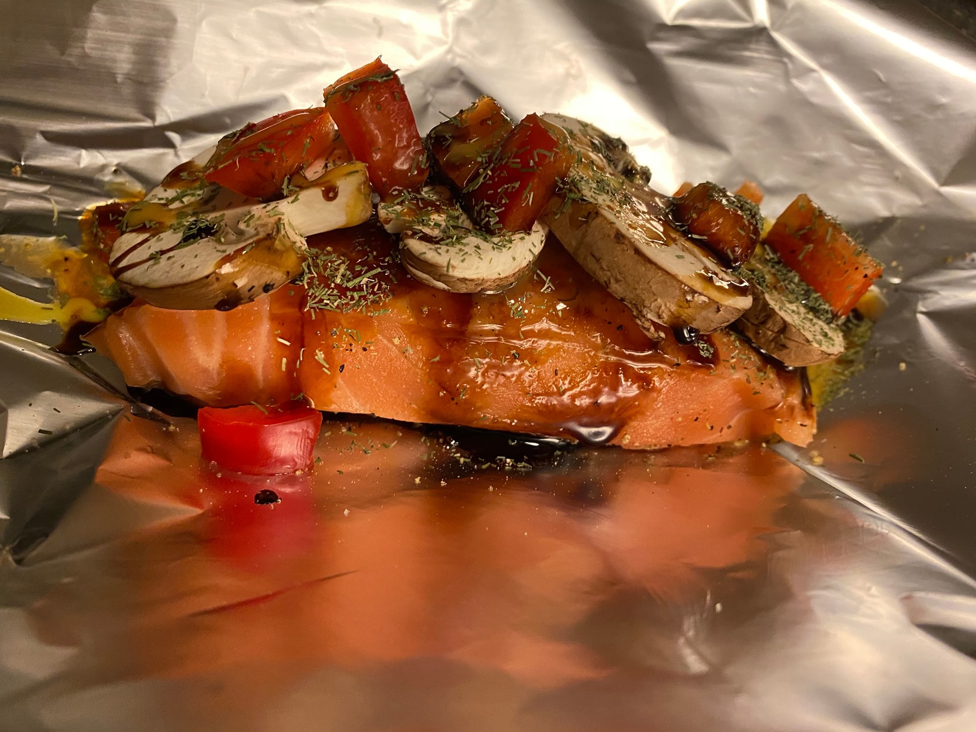 Zalm met groenten in aluminiumfolie, klaar voor de oven