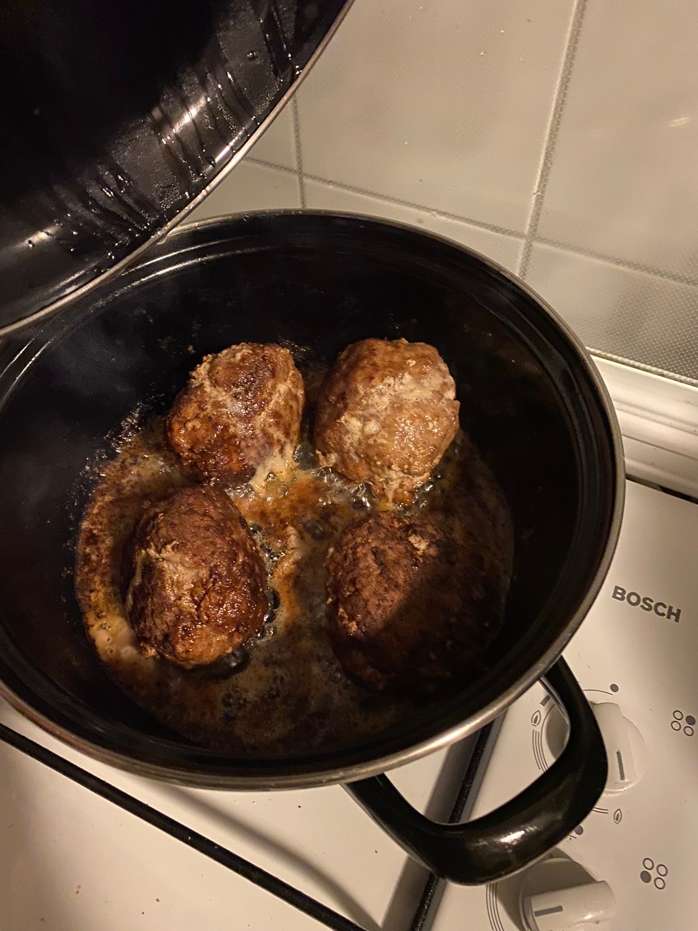Vier gehaktballen in een pan op het fornuis