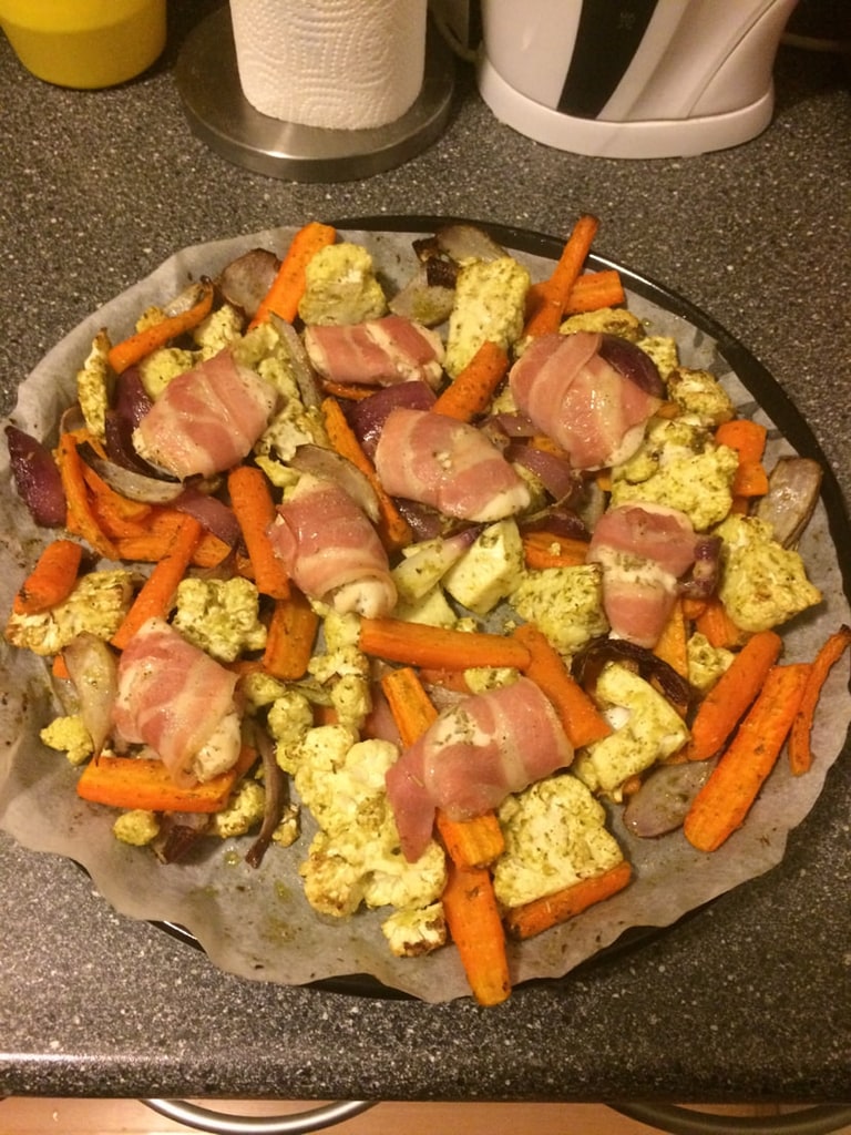 Een pizza belegd met wortel, spek en roerei