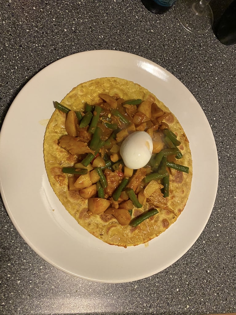 Een bord met gestoofde groenten en een bol mozzarella